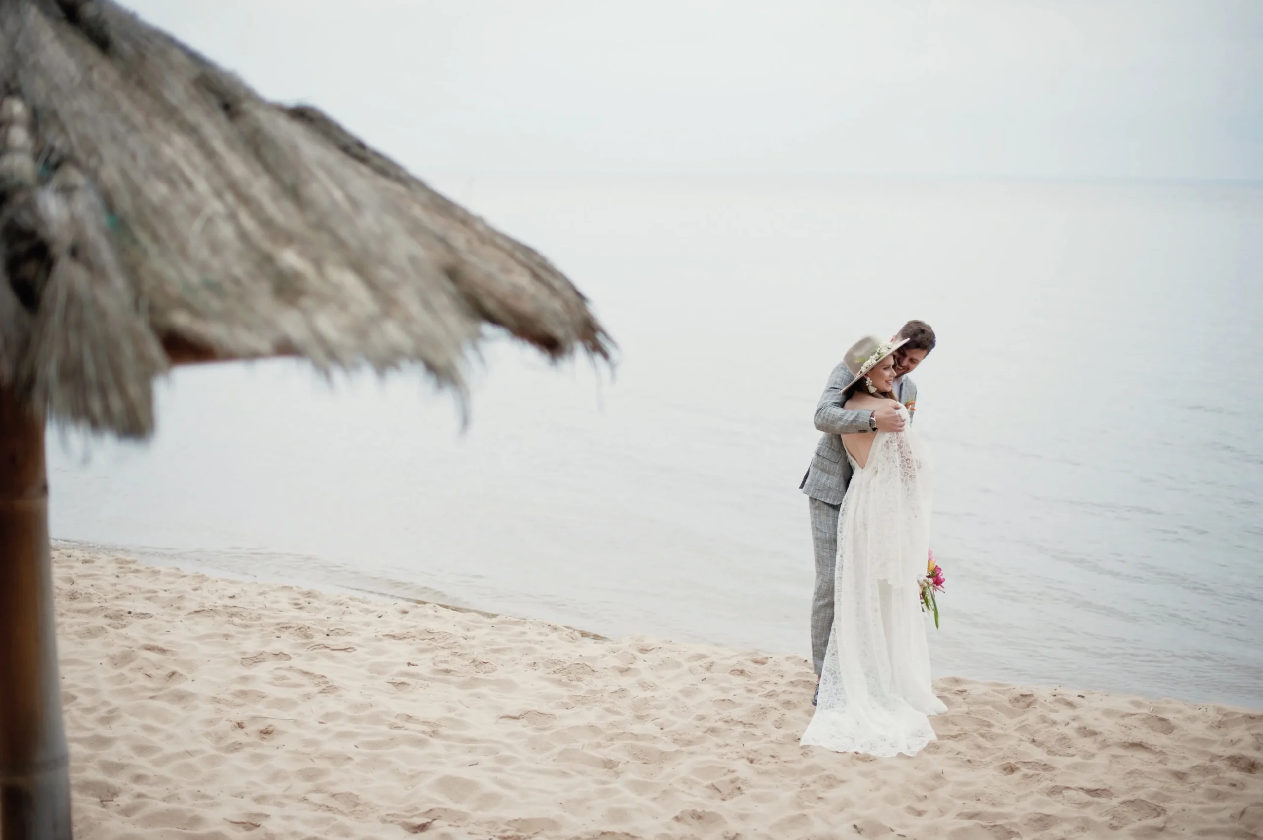 una-pareja-romantica-de-recien-casados-de-pie-en-la-playa-contra-el-cielo (1)_11zon