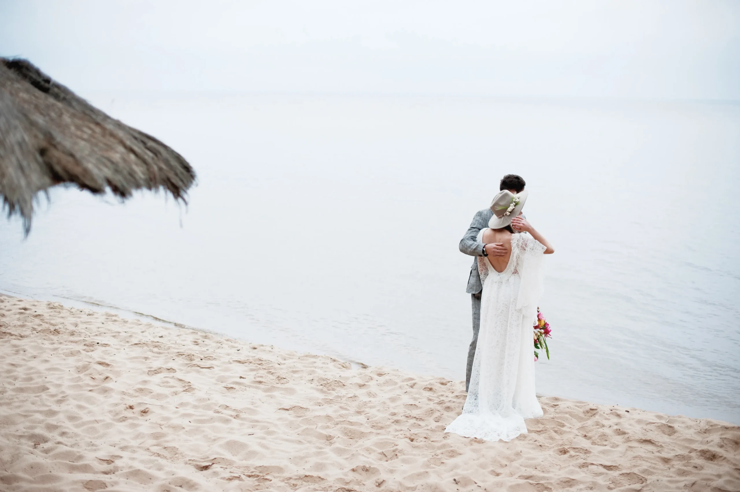 una-pareja-romantica-de-recien-casados-de-pie-en-la-playa-contra-el-cielo_11zon